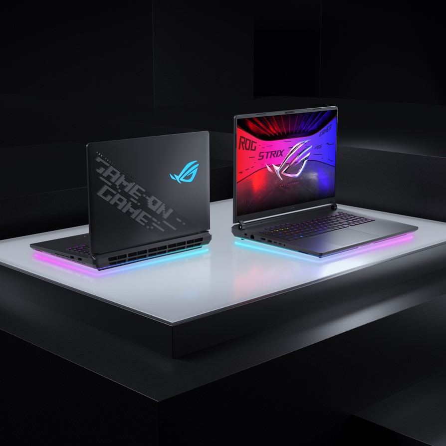 Two ASUS ROG Strix gaming laptops are displayed side by side, featuring RGB lighting, with one showing the text 'GAME ON' on its lid and the other showing 'ROG STRIX' on its screen.