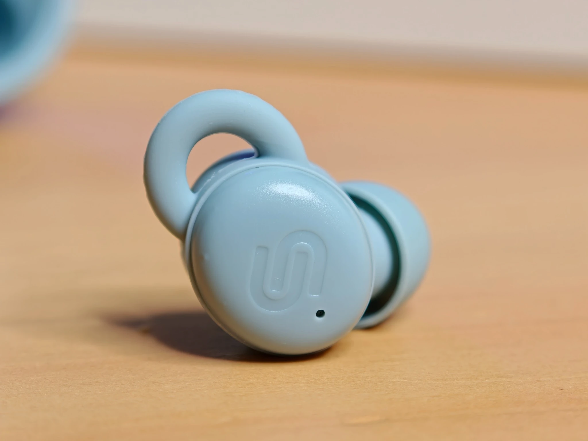 Macro di un auricolare Urbanista Porto Storm Blue con superficie touch e aletta in silicone.