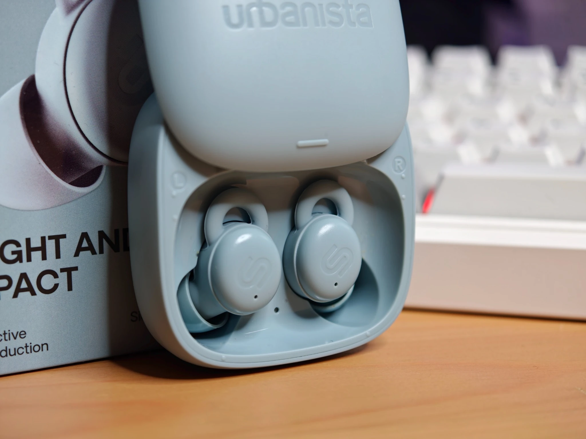 Dettaglio della custodia a scorrimento delle Urbanista Porto con gli auricolari inseriti.